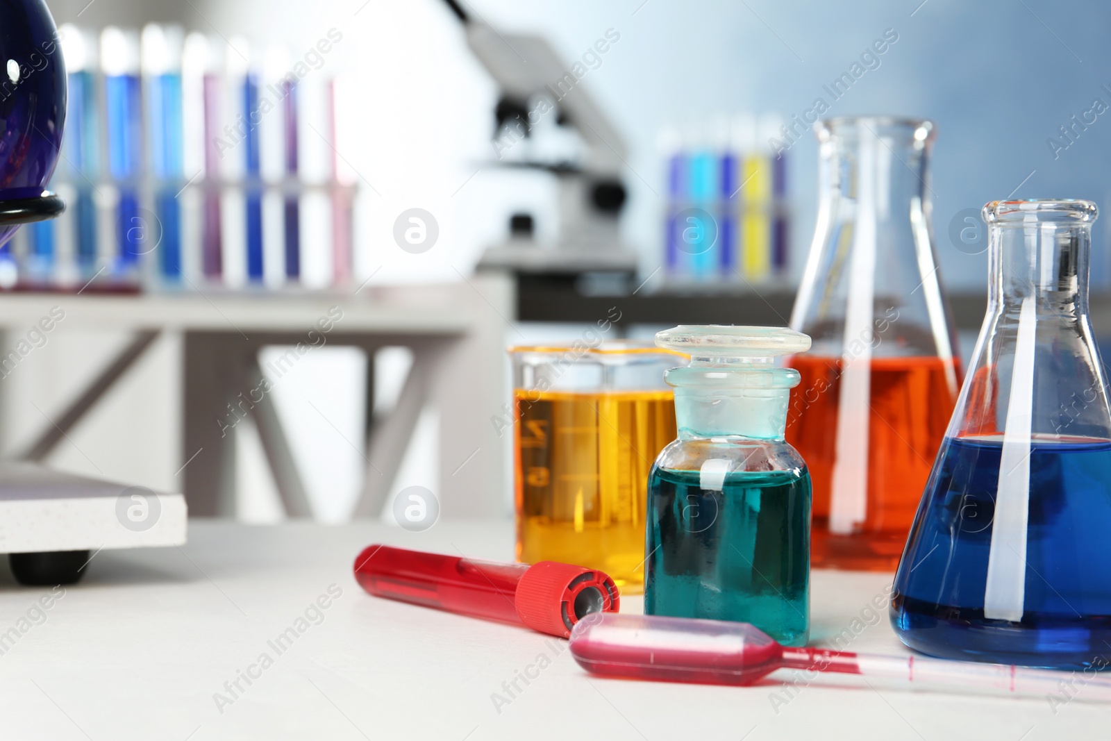 Photo of Different glassware with samples on table in chemistry laboratory