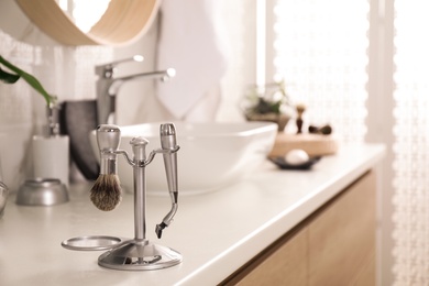 Photo of Shaving accessories on countertop in stylish bathroom