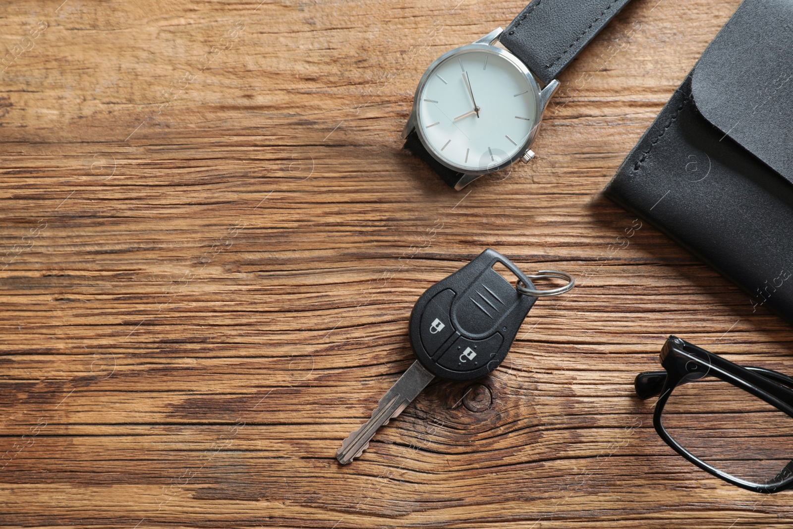 Photo of Flat lay composition with male accessories and car key on wooden background. Space for text