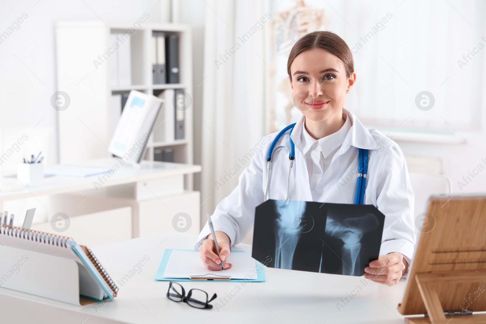 Photo of Orthopedist examining X-ray picture at desk in clinic