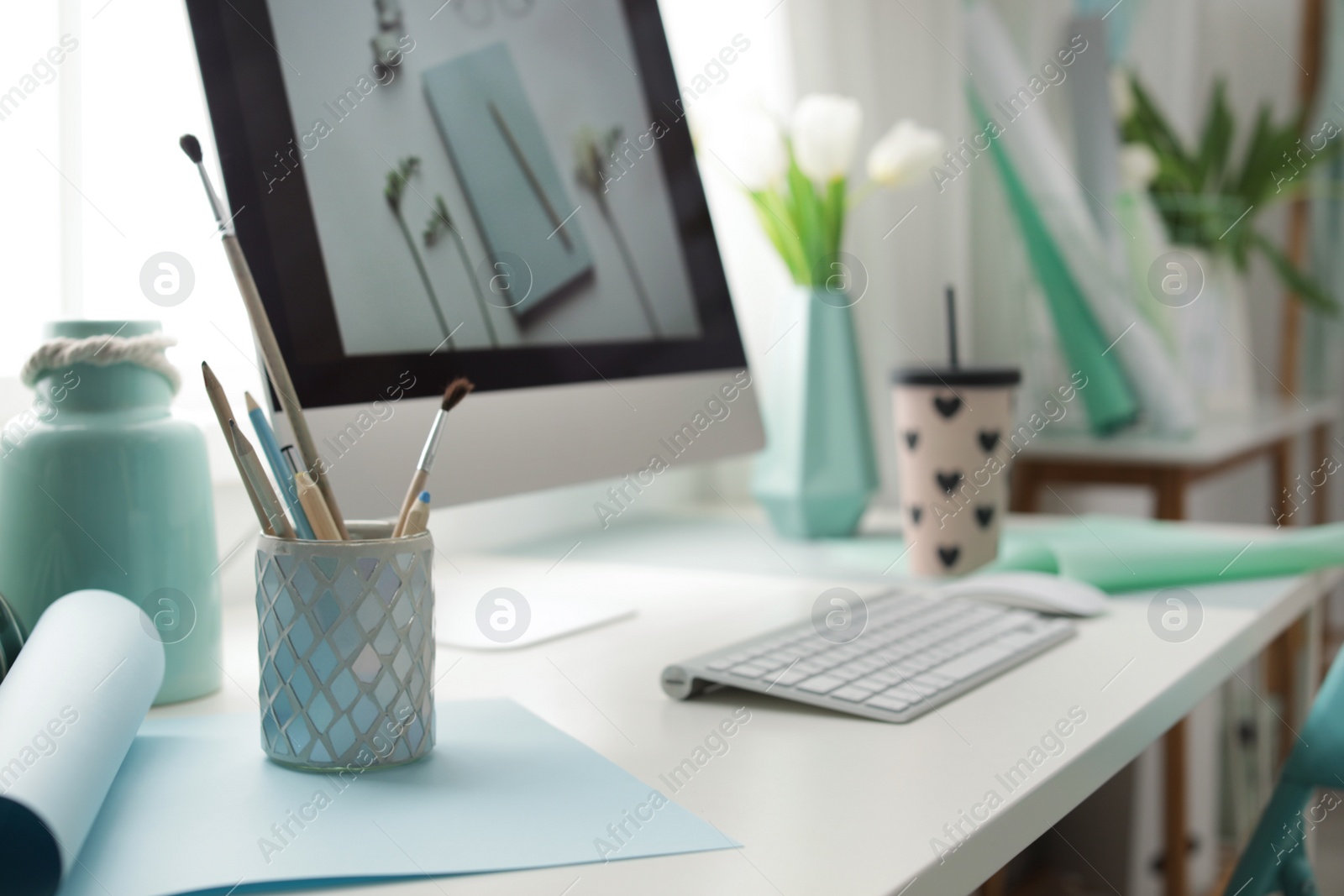 Photo of Stylish workplace with modern computer on desk. Focus on pencil holder