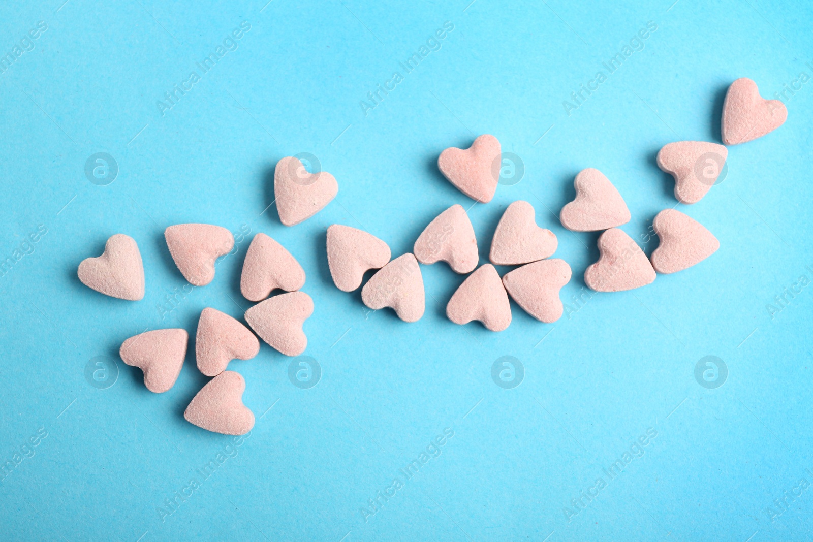 Photo of Flat lay composition with heart shaped candies on color background