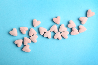 Photo of Flat lay composition with heart shaped candies on color background