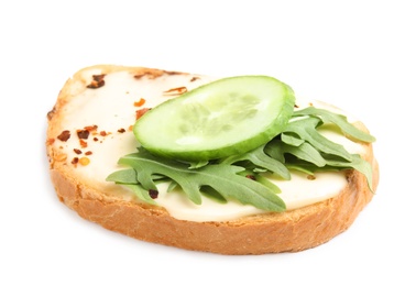 Slice of bread with spread, cucumber and arugula on white background