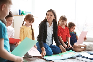 Cute little children with teacher in classroom at school