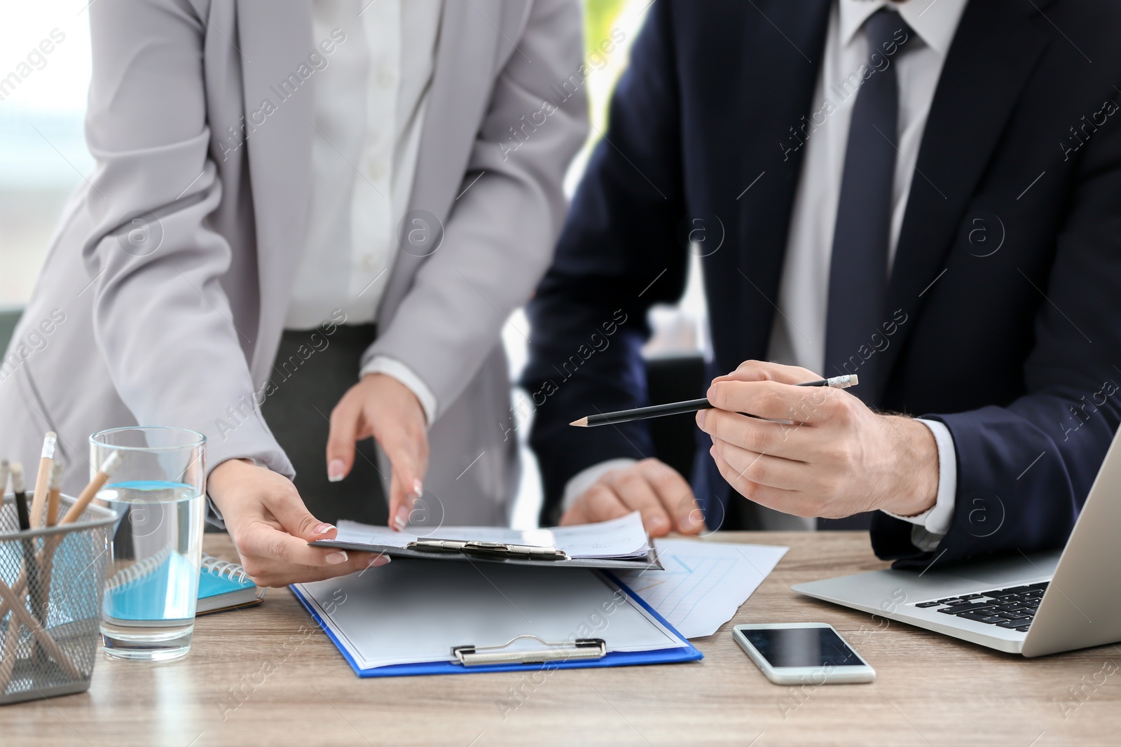 Photo of Young consultant working with client in office