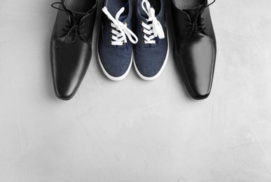 Photo of Flat lay composition with shoes and space for text on gray background. Happy Father's Day