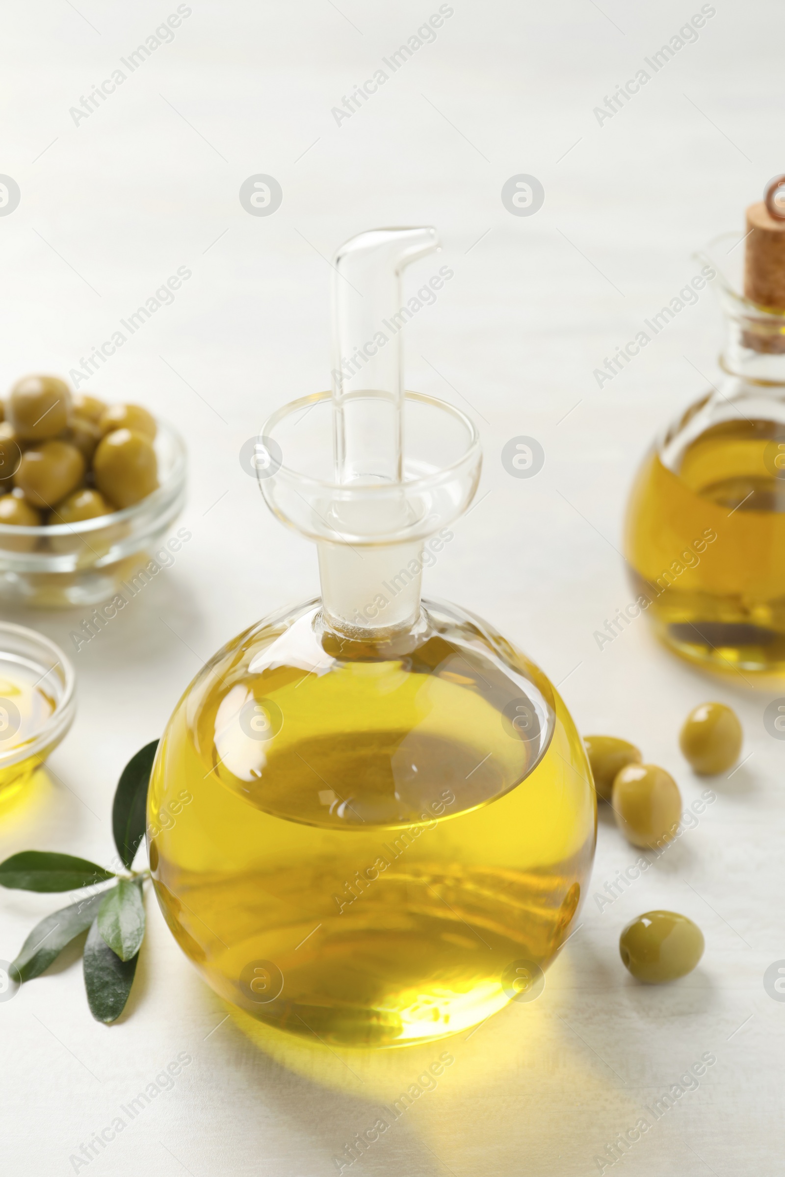 Photo of Bottle of fresh olive oil on white table