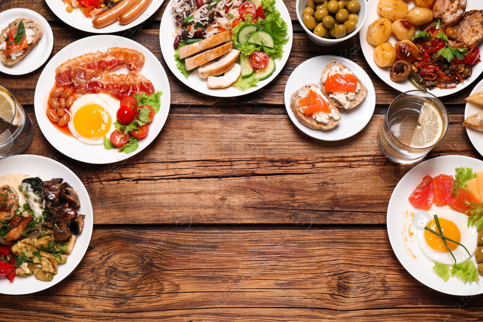 Photo of Buffet service. Flat lay composition with many  different dishes on wooden table, space for text