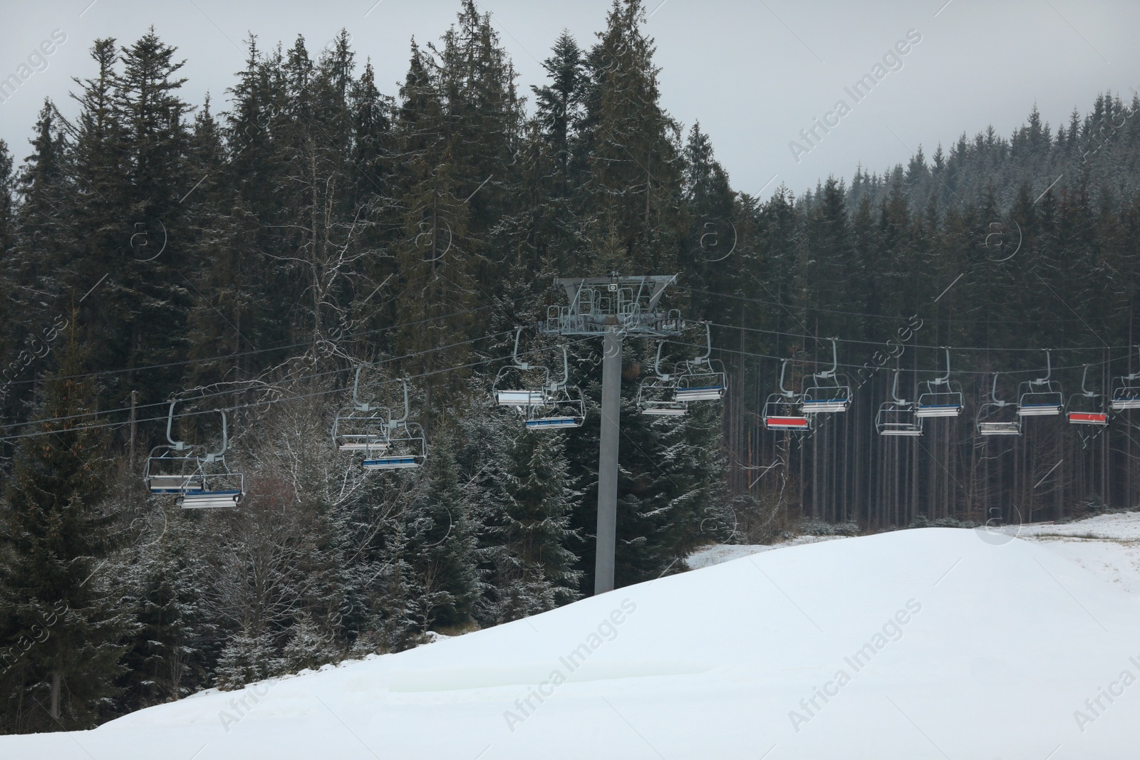 Photo of Beautiful view of ski resort with chairlift on snowy day. Winter vacation