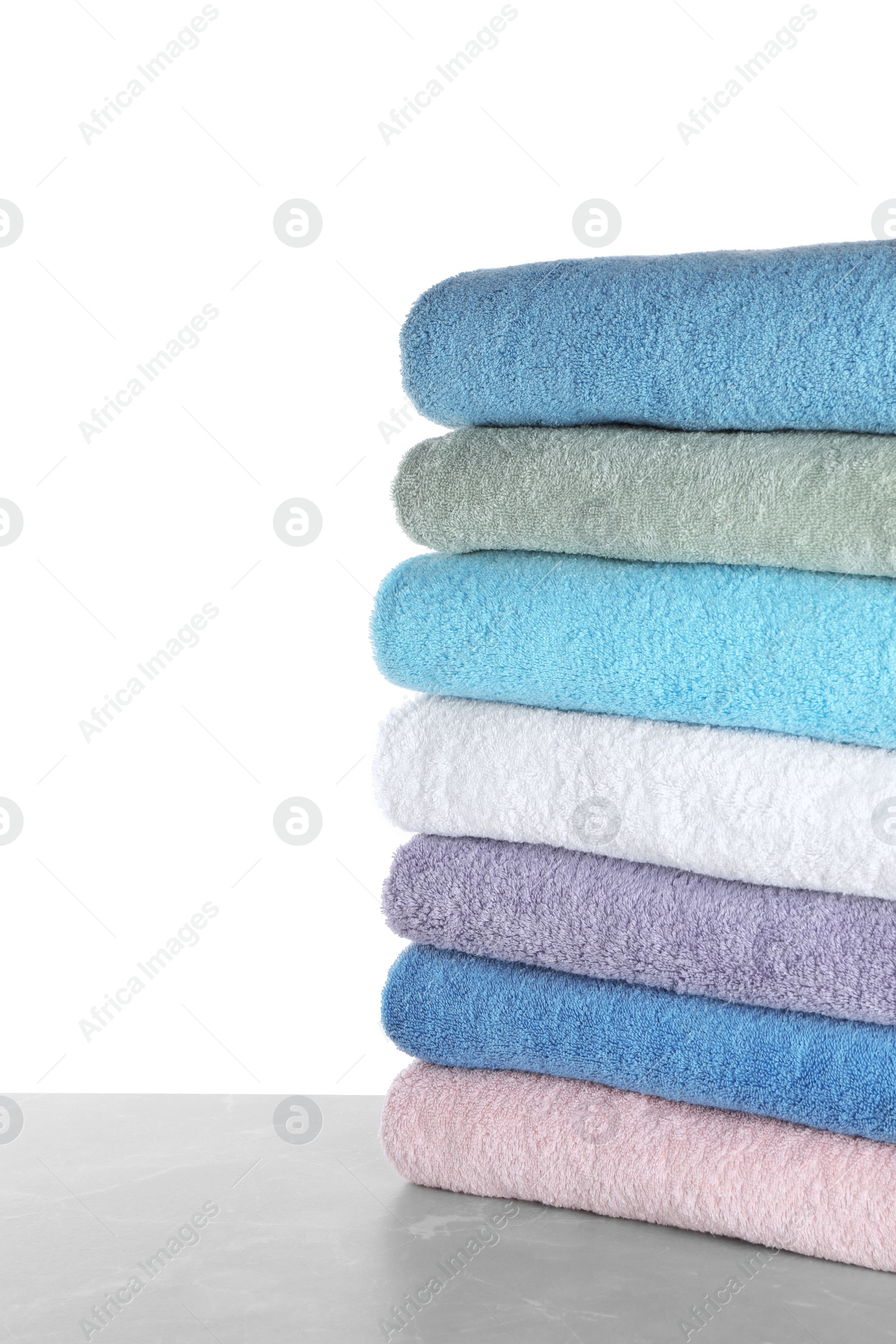 Photo of Fresh towels on light grey marble table against white background