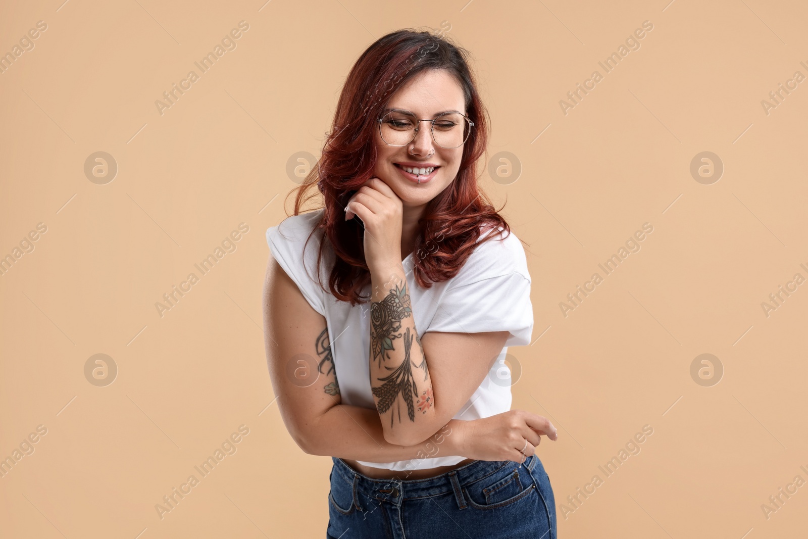 Photo of Portrait of beautiful tattooed woman on beige background