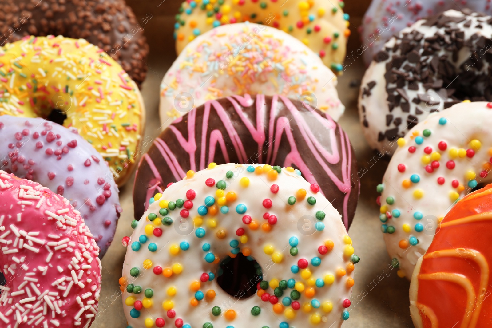 Photo of Yummy glazed donuts with sprinkles, closeup view