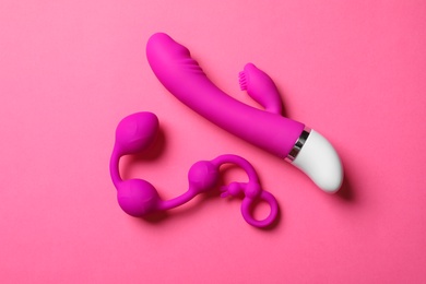 Photo of Anal balls and dildo on pink background, flat lay. Sex toy