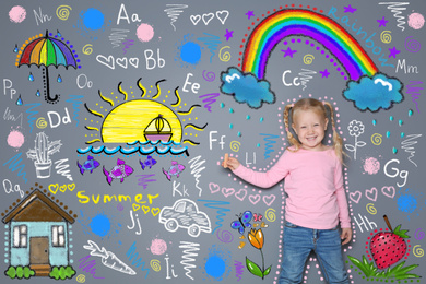 Image of Little girl drawing  with colorful chalk on gray wall