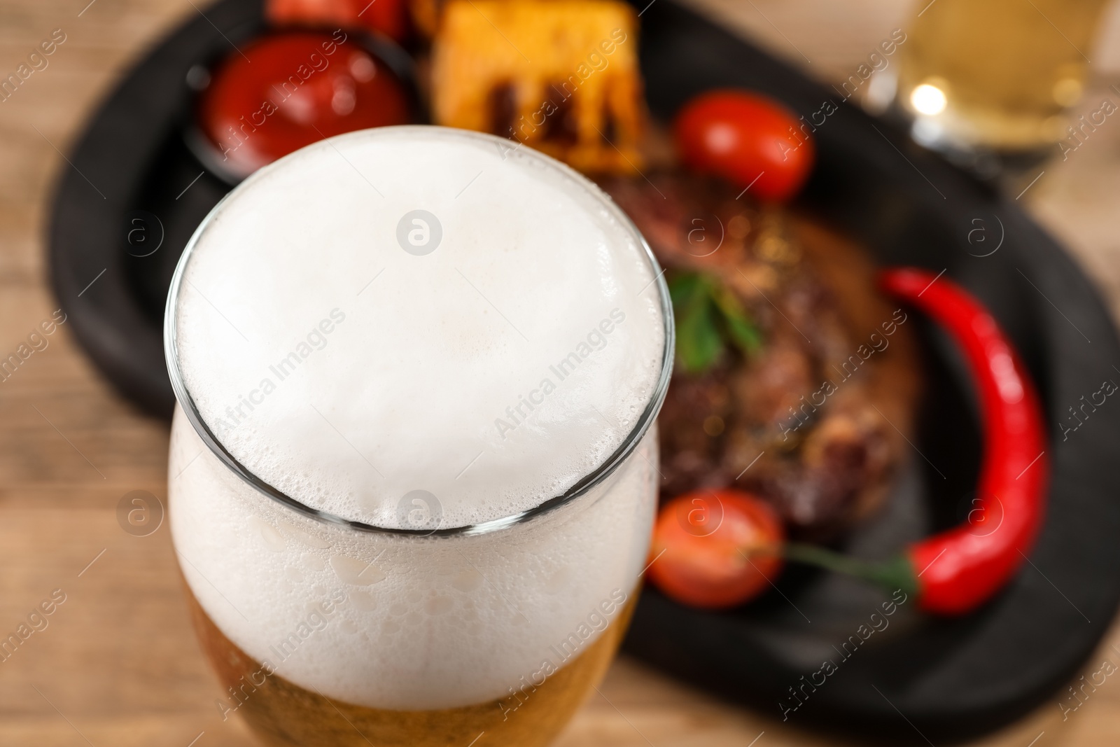 Photo of Glass of tasty beer on table, closeup. Space for text