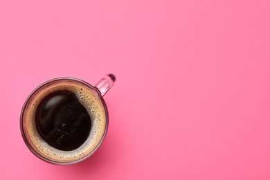 Fresh coffee in cup on pink background, top view. Space for text