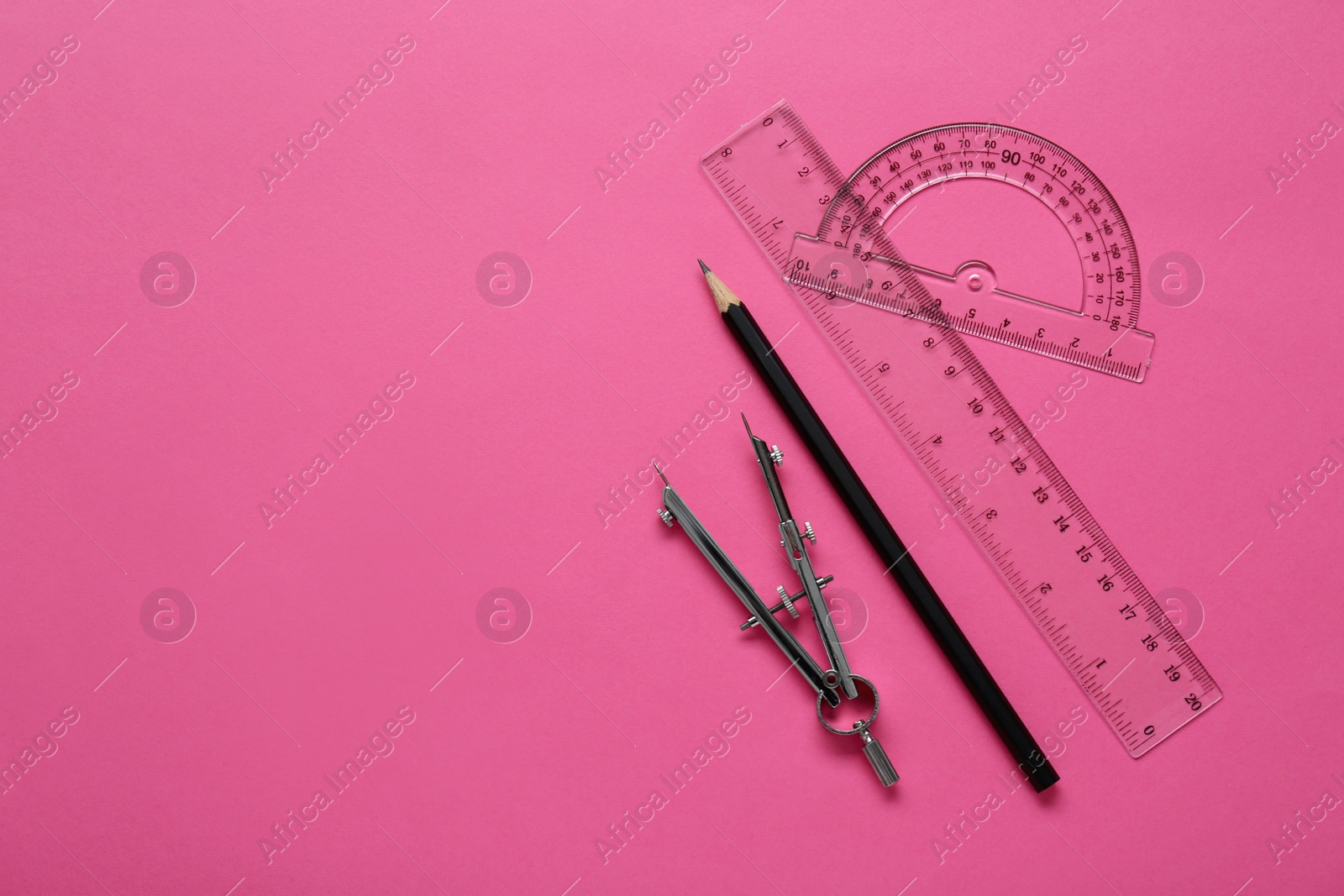 Photo of Ruler, protractor, pencil and compass on pink background, flat lay. Space for text