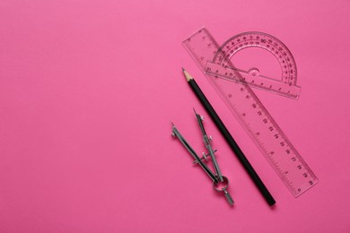 Ruler, protractor, pencil and compass on pink background, flat lay. Space for text
