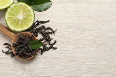 Photo of Dry bergamot tea leaves and fresh fruit on light wooden table, flat lay. Space for text