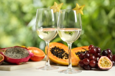 Delicious exotic fruits and wine on white table