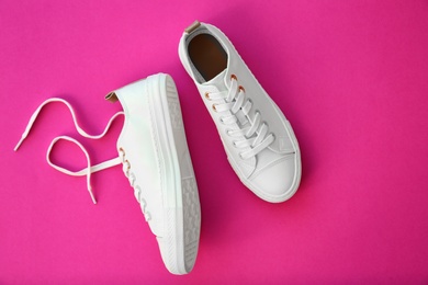 Photo of Pair of casual shoes on color background