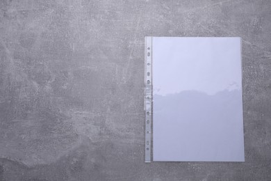 Punched pocket with paper sheet on light grey table, top view. Space for text