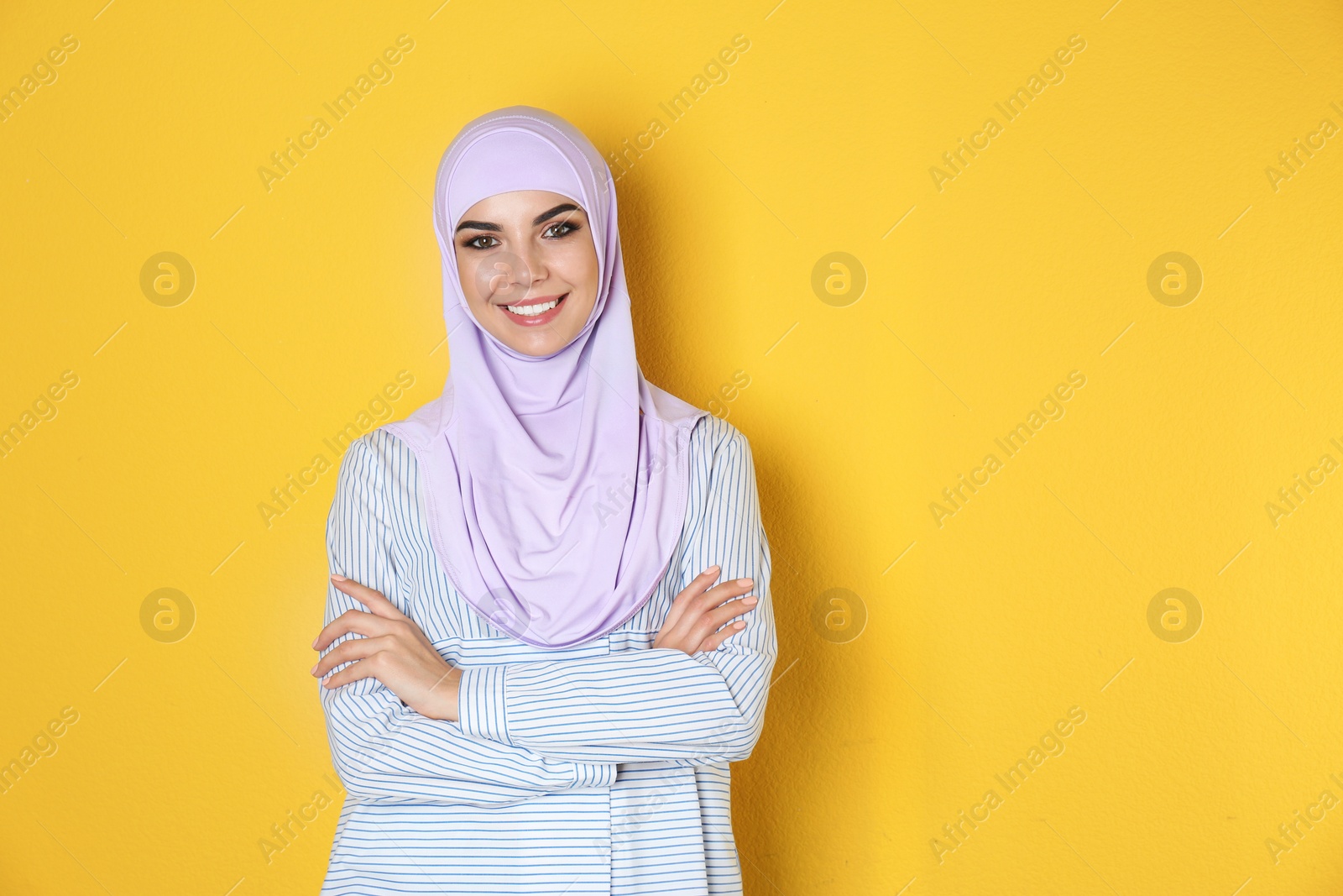 Photo of Portrait of young Muslim woman in hijab against color background. Space for text