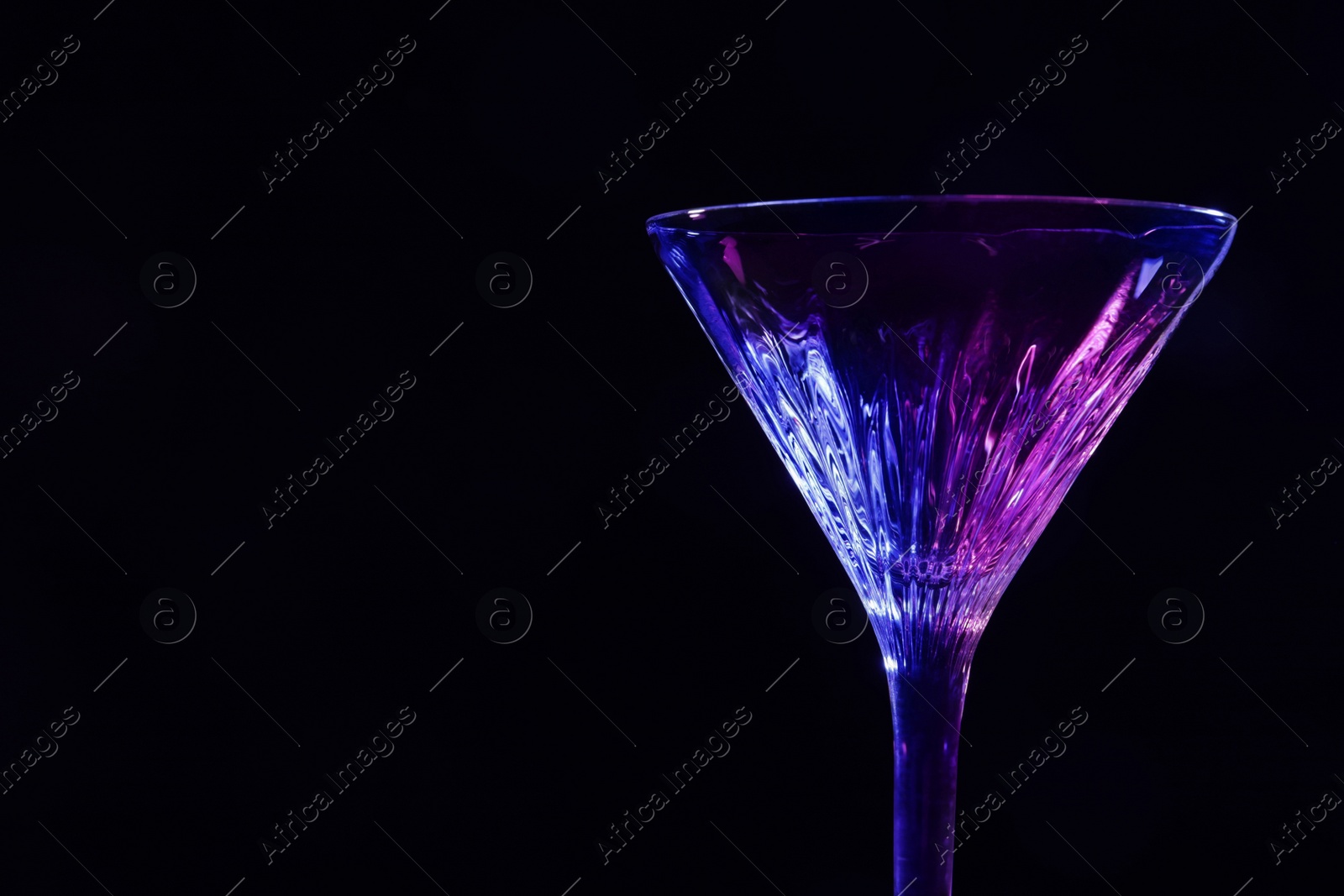 Photo of Beautiful martini glass on black background. Space for text