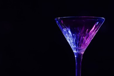 Photo of Beautiful martini glass on black background. Space for text