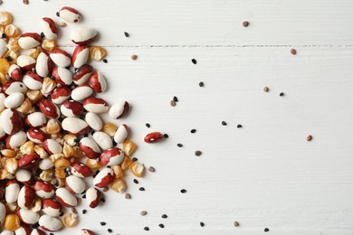 Photo of Mixed vegetable seeds on white wooden background, flat lay