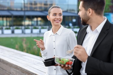 Photo of Smiling business woman talking with her colleague during lunch outdoors. Space for text