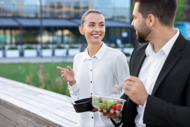 Smiling business woman talking with her colleague during lunch outdoors. Space for text