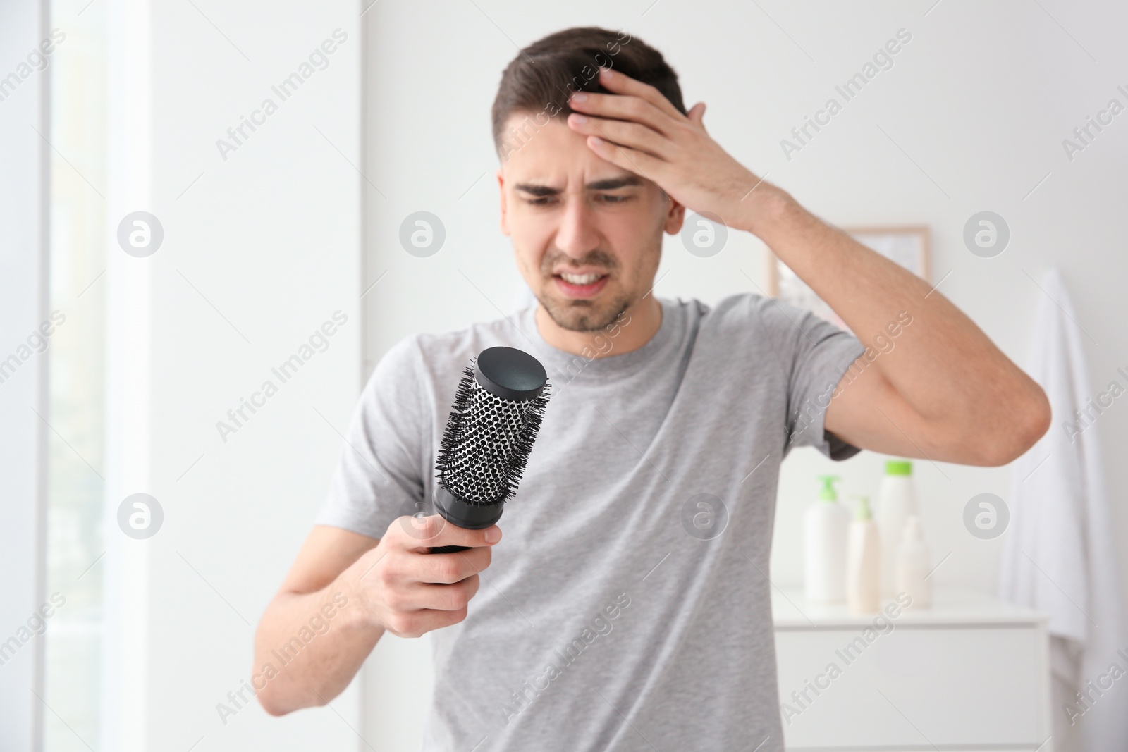 Photo of Young man with hair loss problem indoors