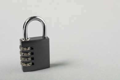 One steel combination padlock on grey background, closeup. Space for text