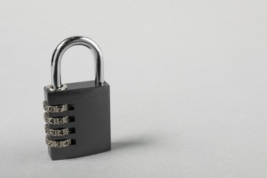 Photo of One steel combination padlock on grey background, closeup. Space for text