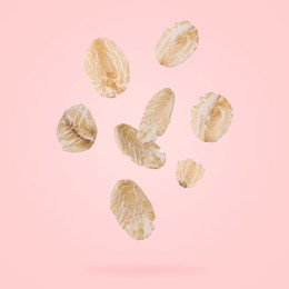 Image of Rolled oat flakes falling on pink background