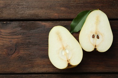 Halves of tasty fresh pear on wooden table, flat lay. Space for text