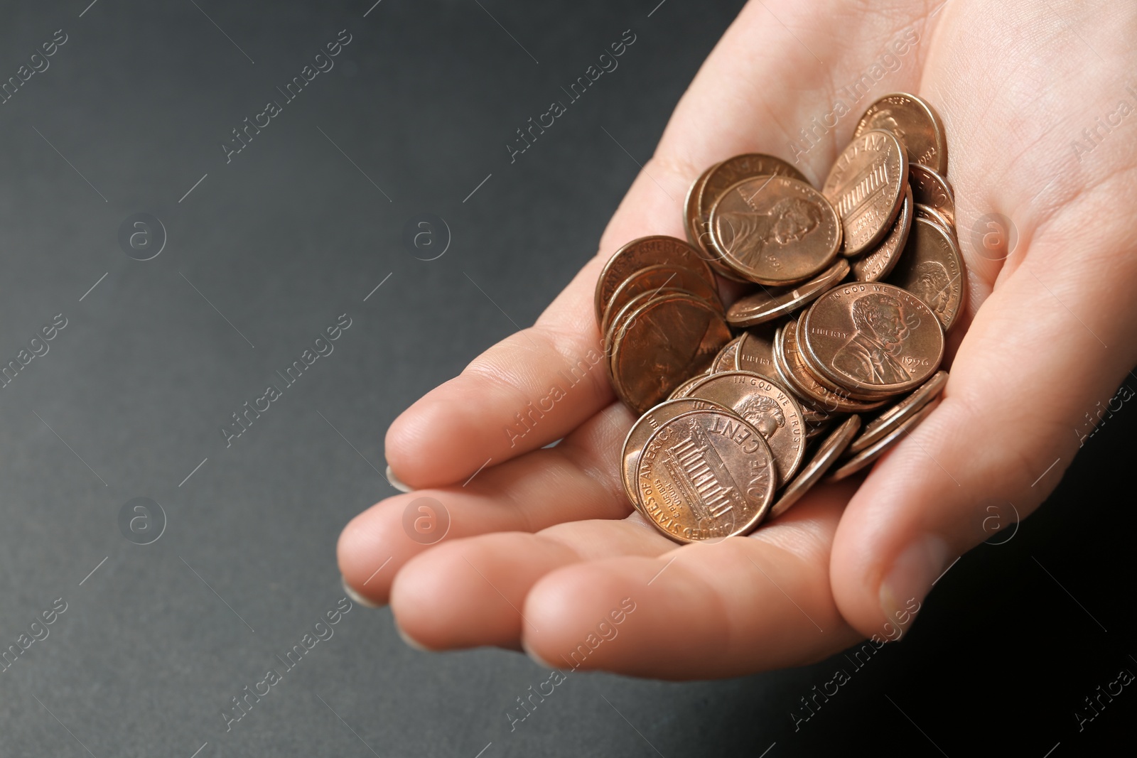 Photo of Young woman holding coins on black background, closeup view