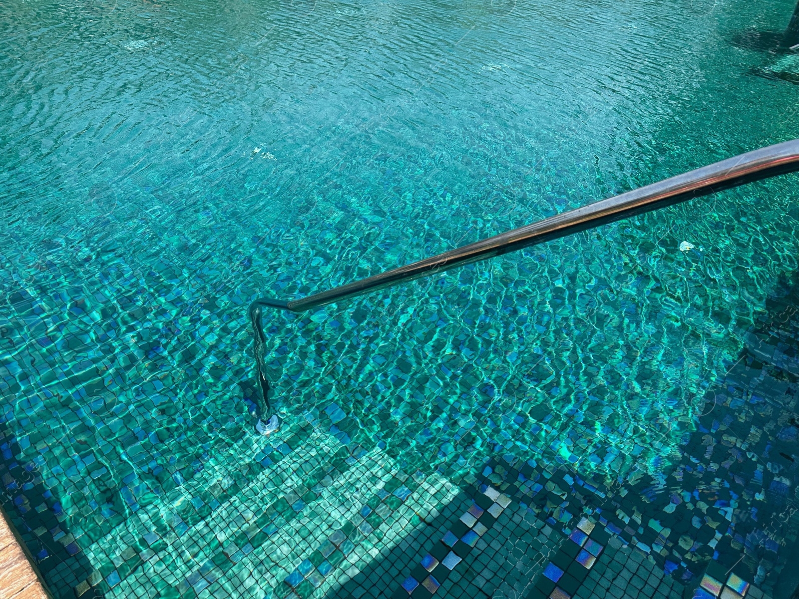 Photo of Metal rail and steps in outdoor swimming pool