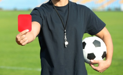 Photo of Football referee showing red card at stadium, closeup