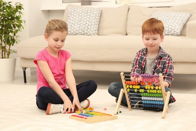 Photo of Children playing with different math game kits on floor in living room. Study mathematics with pleasure