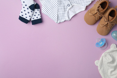 Flat lay composition with child's clothes and accessories on violet background, space for text
