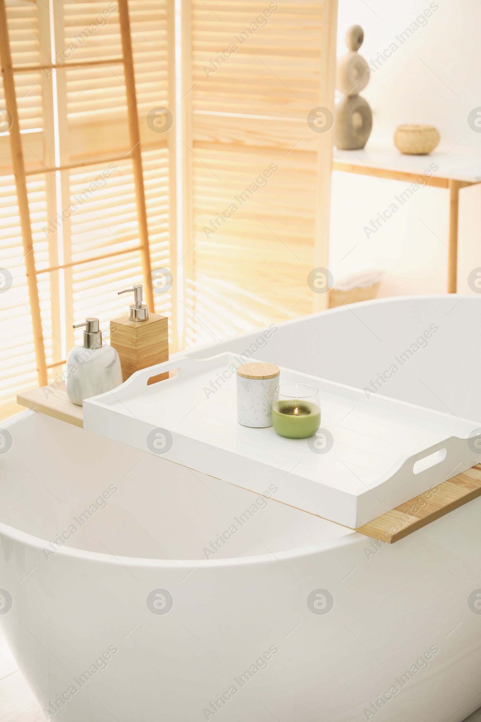 Photo of Scented candles on tray for tub in bathroom. Interior design
