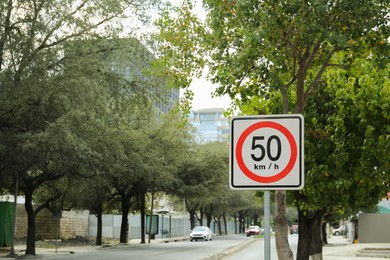 Photo of Post with road sign Maximum Speed 50 on city street