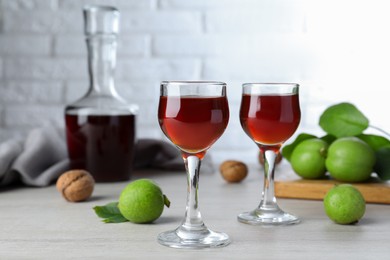 Photo of Delicious liqueur and fresh walnuts on wooden table