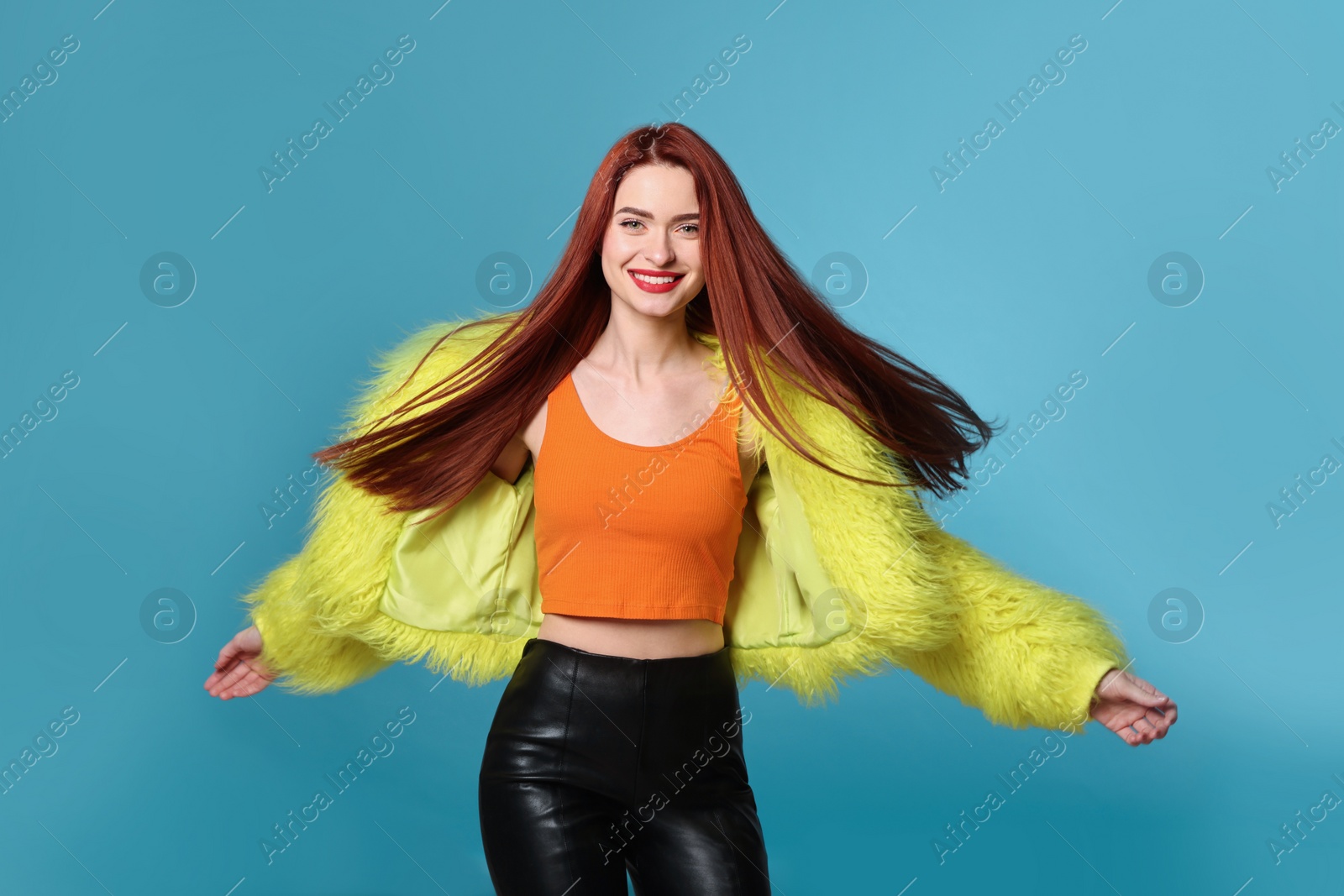 Photo of Stylish woman with red dyed hair on light blue background