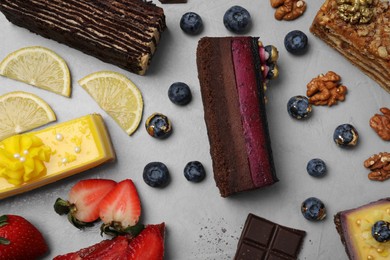 Photo of Flat lay composition with different tasty cakes on light grey table