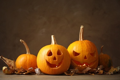 Photo of Composition with pumpkin heads on dark background. Jack lantern - traditional Halloween decor