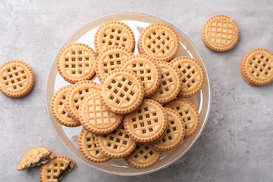 Photo of Tasty sandwich cookies with cream on grey table, flat lay